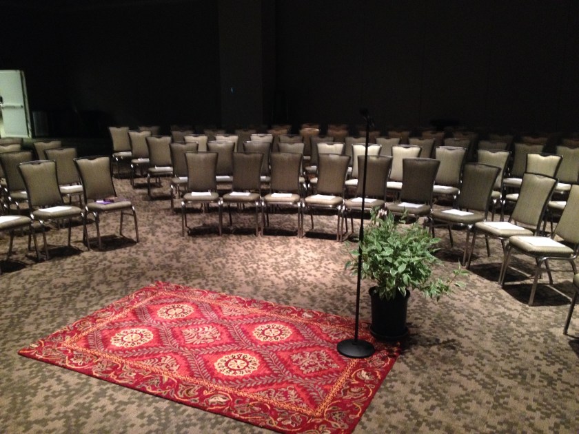 A big room can still feel like a stage with a little light control, oval seating... and a rug and plant.