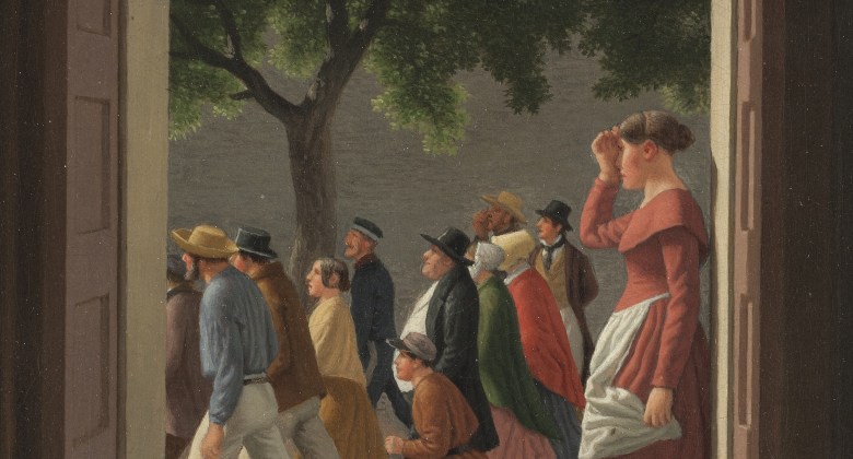 View through an open doorway. A woman stands in the door looking left. Outside a crowd of people are running towards the left.